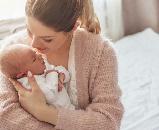 Mama hält ihr Baby liebevoll im Arm