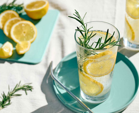 Wasser im Glas mit Zitronen und Rosmarin