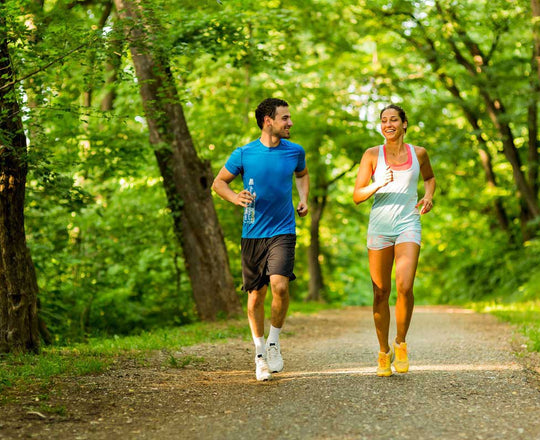 Frau und Mann joggen gemeinsam durch einen Wald