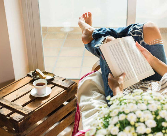 Frau liest ein Buch und genießt eine Tasse Kaffee
