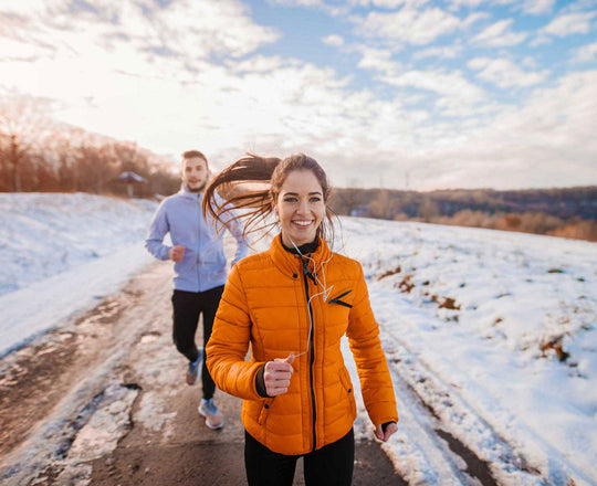 Frau und Mann laufen gemeinsam in einer Winterlandschaft