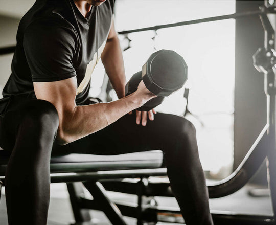 Mann hebt Gewichte in einem Fitnessstudio
