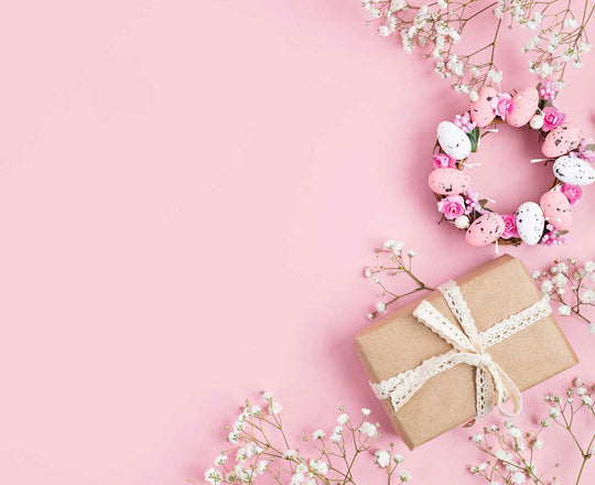 Geschenke, Blumen und Ostereier auf einem rosa Untergrund
