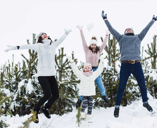 Familie springt fröhlich im Schnee