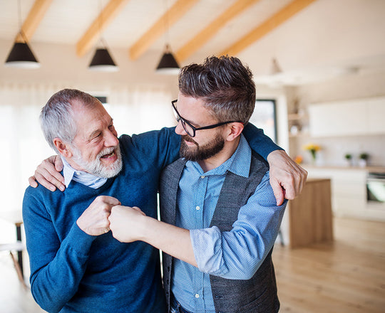 Zwei Männer umarmen sich und geben sich dabei einen freundschaftlichen Schlag mit der Faust