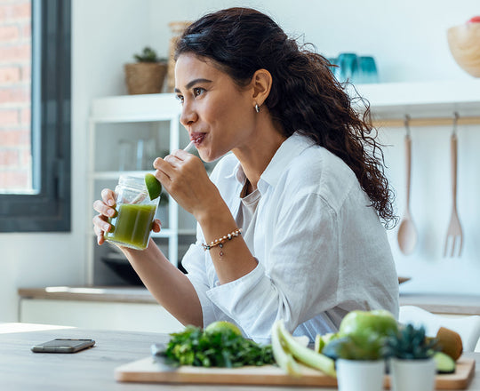 Frau trinkt einen grünen Detox-Saft