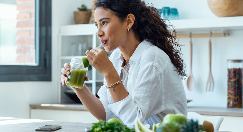 Frau trinkt einen grünen Detox-Saft
