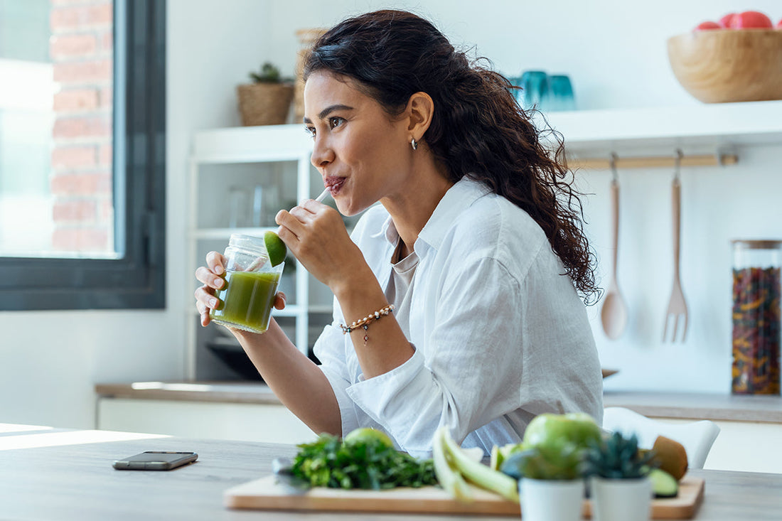 Frau trinkt einen grünen Detox-Saft