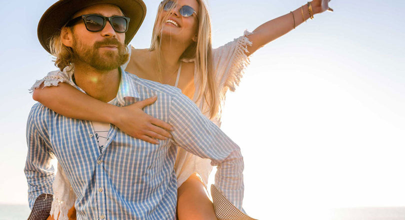 Mann trägt die Frau auf seinem Rücken und beide genießen den Sonnenschein