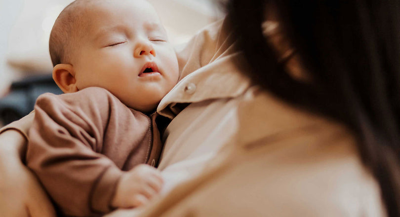 Eine Mama hält ihr Baby liebevoll im Arm