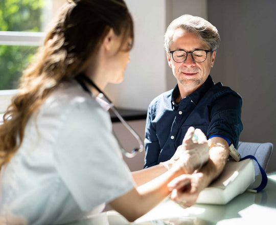 Medizinische Assistentin nimmt Blut bei einem Patienten ab