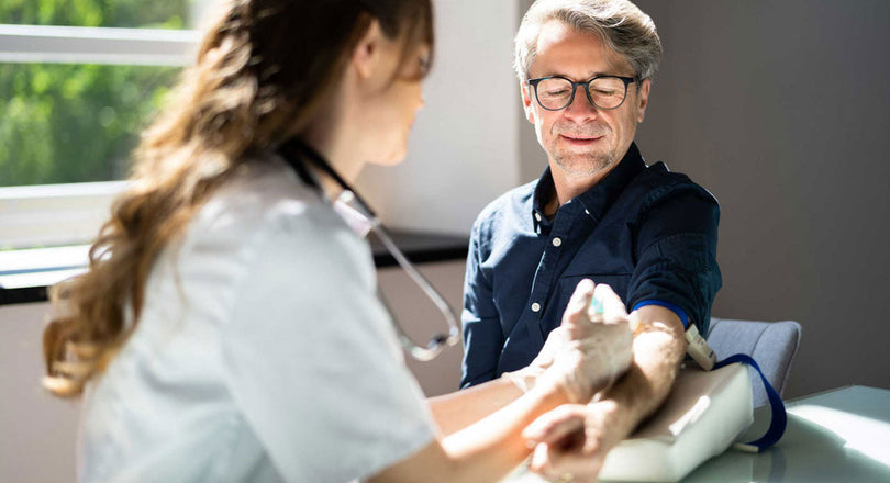 Medizinische Assistentin nimmt Blut bei einem Patienten ab