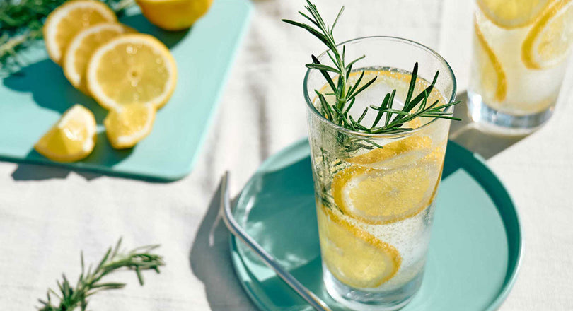 Wasser im Glas mit Zitronen und Rosmarin