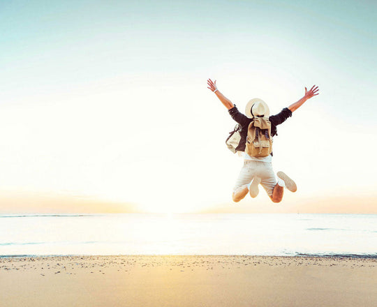 Mann springt am Strand in die Luft