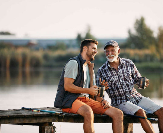 Zwei Männer sitzen an einem Steg am See