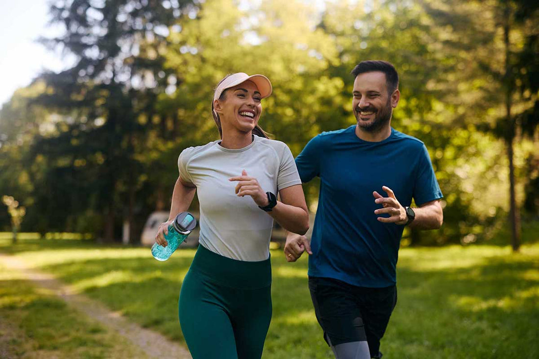 Eine Frau und ein Mann joggen durch die grüne Natur