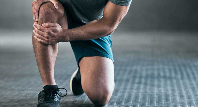 Ein Mann kniet auf dem Boden und hält sein schmerzendes Knie