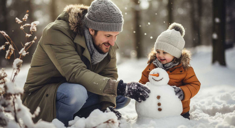 Vater baut mit seiner Tochter einen Schneemann