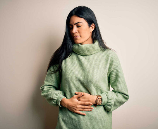 Frau hält sich schmerzerfüllt den Bauch