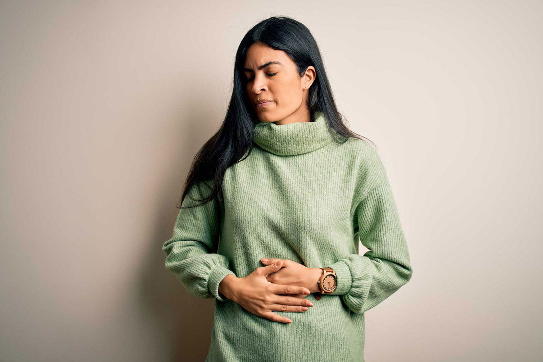 Frau hält sich schmerzerfüllt den Bauch