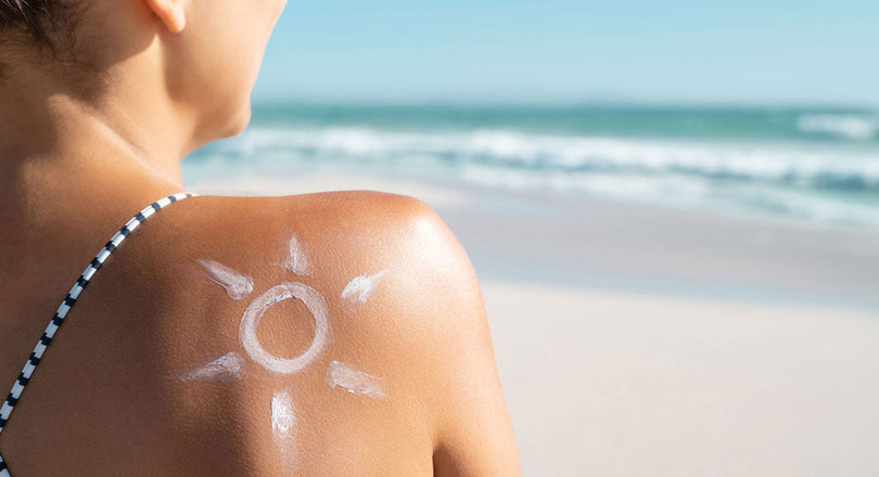 Auf dem Rücken der Frau ist eine Sonne aus Sonnencreme aufgetragen