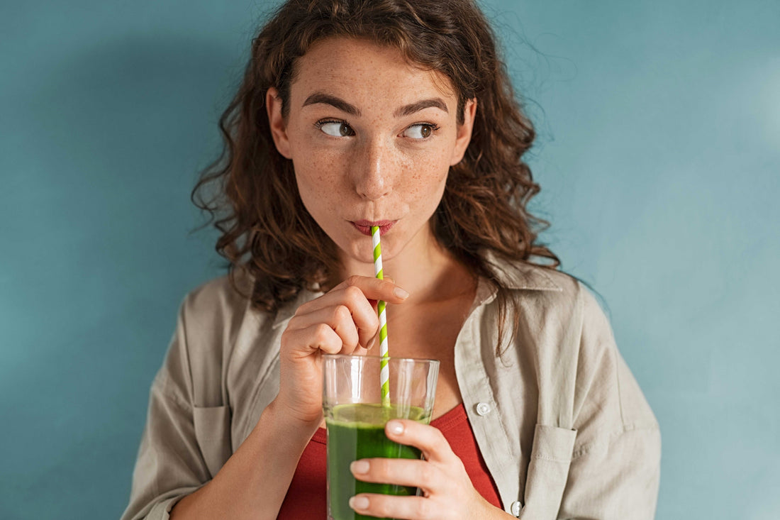 Junge Frau mit einem grünen Smoothie