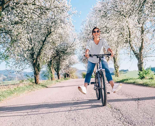 Frau fährt im Frühling mit dem Fahrrad