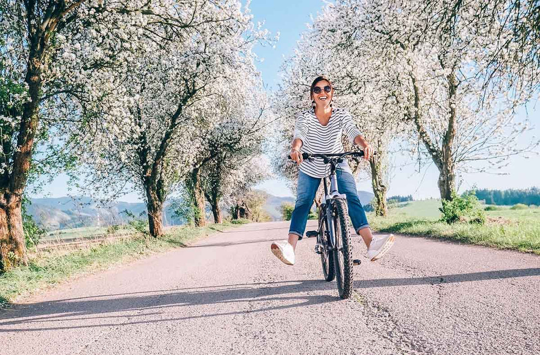 Frau fährt im Frühling mit dem Fahrrad