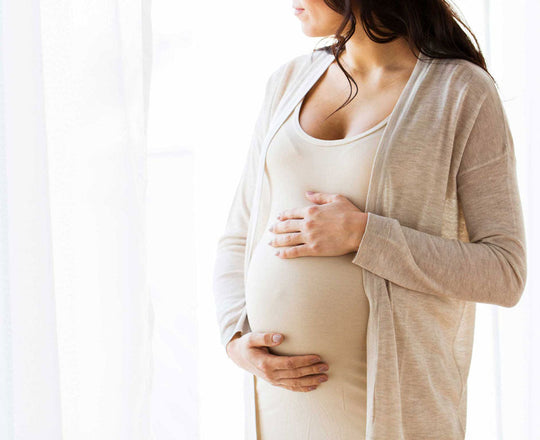 Eine schwangere Frau hält schützend ihren Babybauch