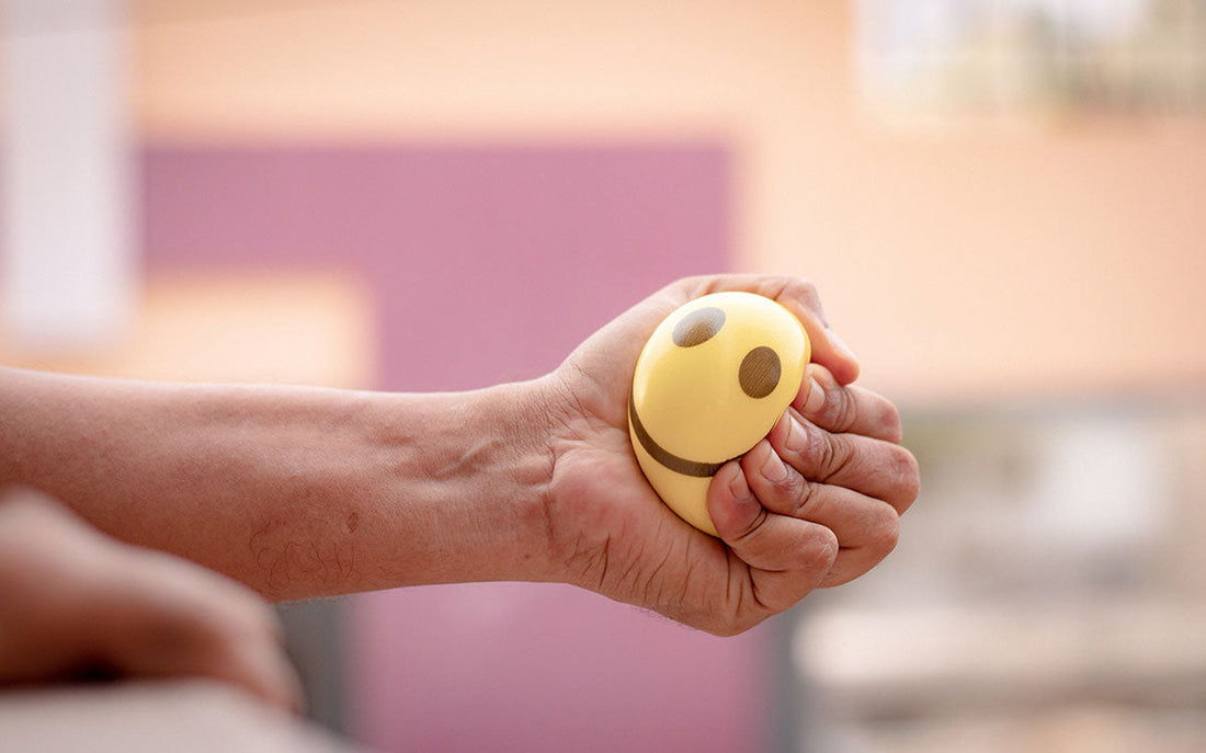 Frau hält einen Anti-Stress-Ball in der Hand und drückt ihn zusammen