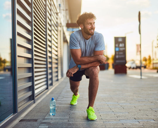 Mann im Sportoutfit dehnt sich nach dem Laufen