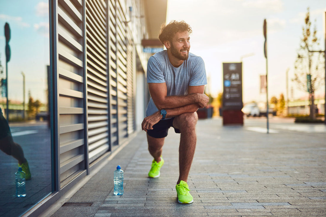 Mann im Sportoutfit dehnt sich nach dem Laufen