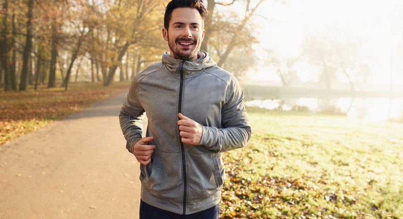 Mann läuft durch einen herbstlichen Wald