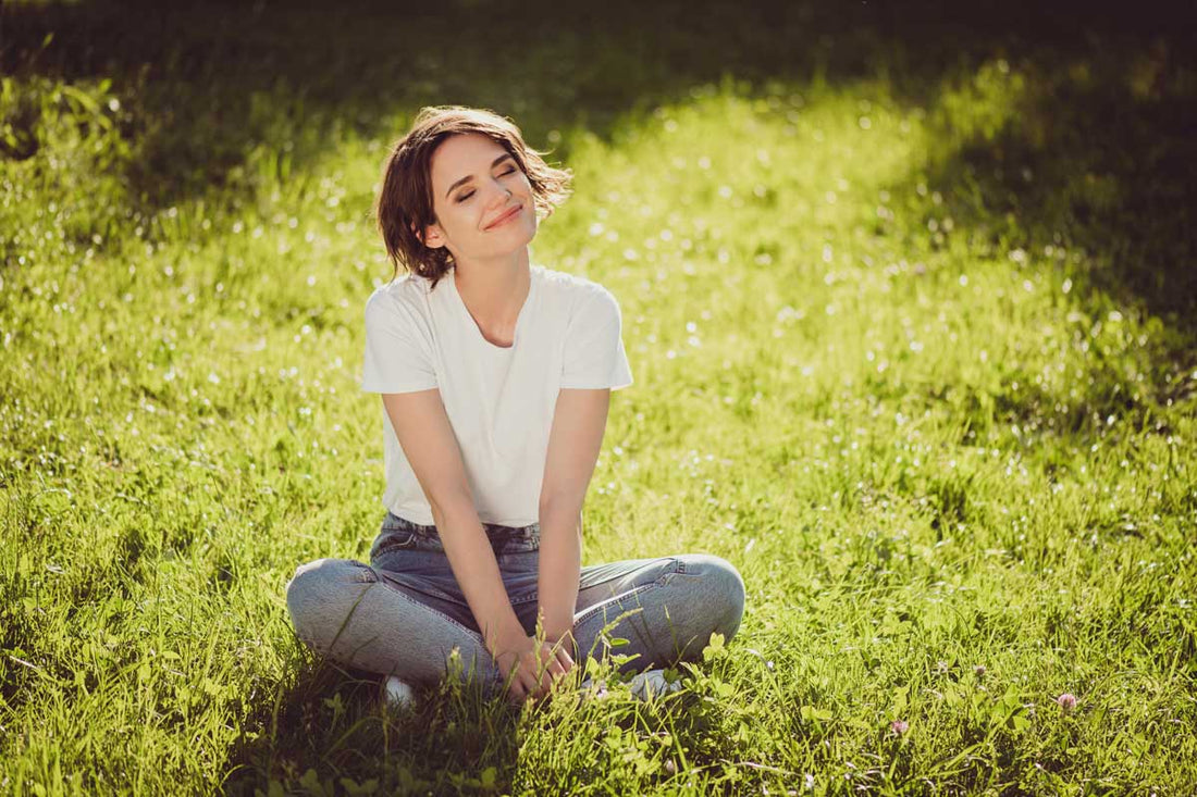 Frau sitzt im Gras und lächelt