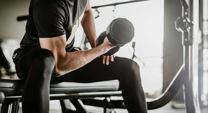 Mann hebt Gewichte in einem Fitnessstudio