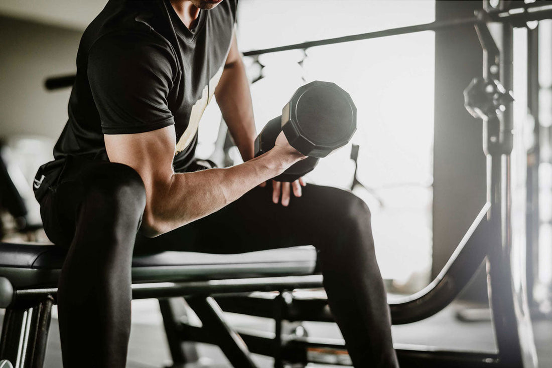 Mann hebt Gewichte in einem Fitnessstudio
