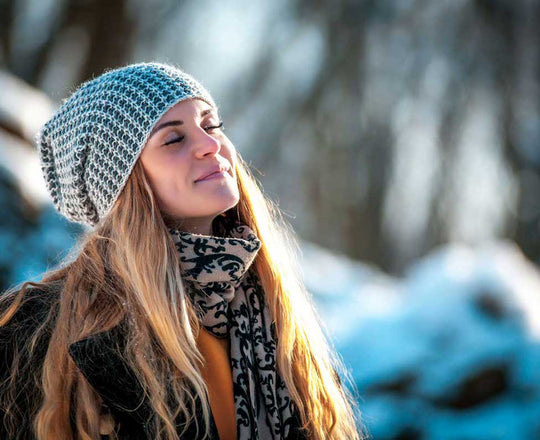 Frau genießt die Sonne mit geschlossenen Augen
