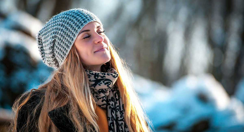 Frau genießt die Sonne mit geschlossenen Augen