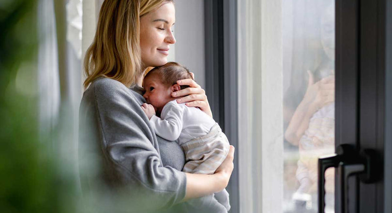 Fürsorgliche Mama hält ihr Baby auf dem Arm