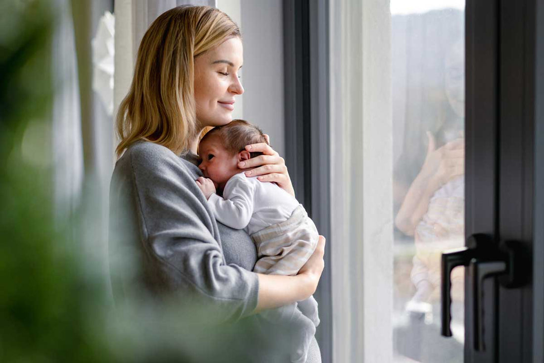 Fürsorgliche Mama hält ihr Baby auf dem Arm