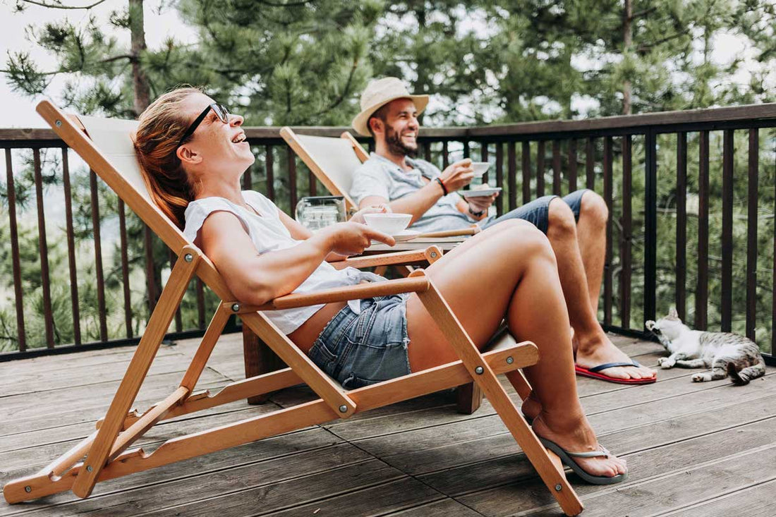 Eine Frau und ein Mann sitzen nebeneinander in Liegestühlen und lachen