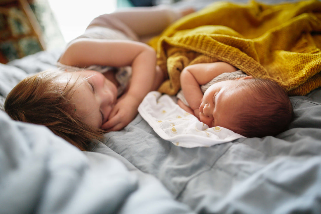 Baby und Kind liegen im Bett