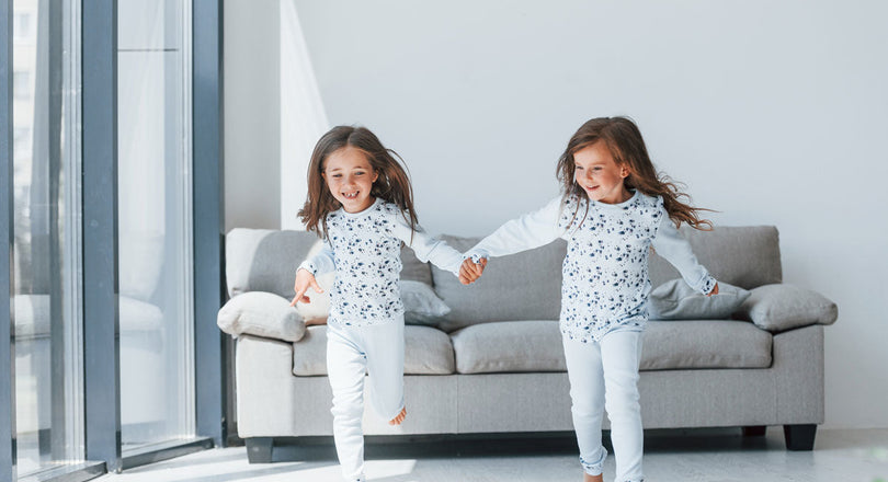 Zwei Mädchen laufen durch ein Wohnzimmer