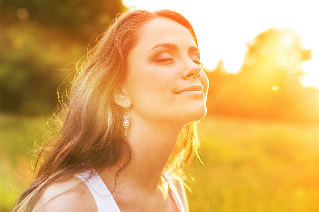Frau genießt die Sonne mit erhobenem Gesicht