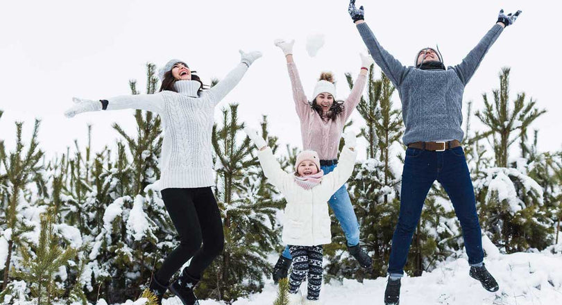 Familie springt fröhlich im Schnee