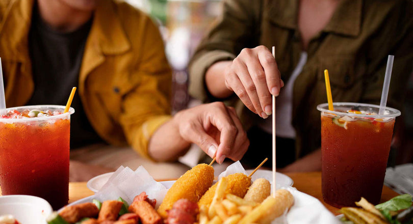 Zwei Personen sitzen an einem Tisch und essen Fastfood