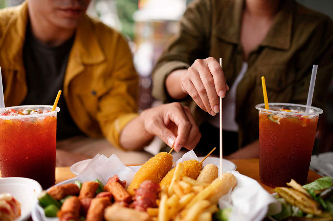Zwei Personen sitzen an einem Tisch und essen Fastfood