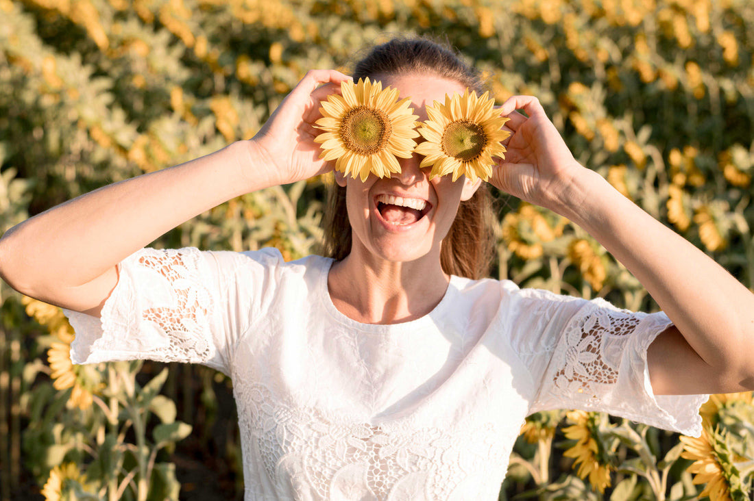 Glückliche Frau mit Sonnenblumen vor den Augen